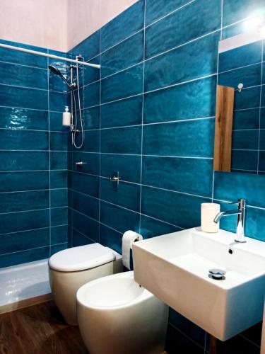 a bathroom with a white toilet and a sink at Vigna di pettineo - guest house in Vittoria