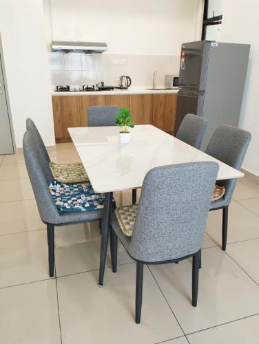 a white table and chairs with a potted plant on it at JB Austin Regency @ Simple Tidy Comfort 7 pax in Johor Bahru