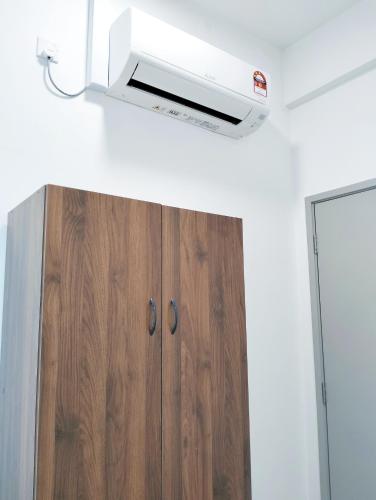 a room with a ceiling fan and a wooden cabinet at JB Austin Regency @ Simple Tidy Comfort 7 pax in Johor Bahru