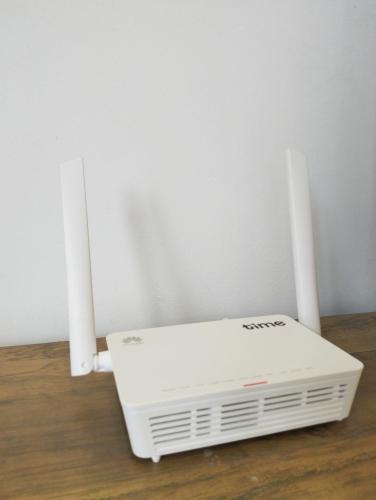a white router sitting on a wooden floor with two speakers at JB Austin Regency @ Simple Tidy Comfort 7 pax in Johor Bahru
