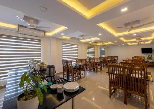 a dining room with tables and chairs in a restaurant at Airport Avenue Plaza in Nedumbassery