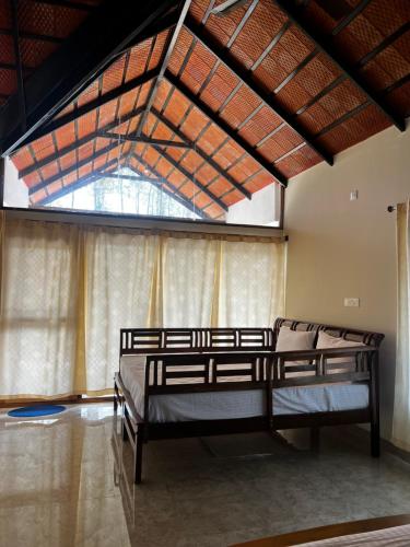 um quarto com 2 camas e uma grande janela em Coorg Coffee Inn em Suntikoppa