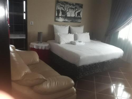 ein Hotelzimmer mit einem großen Bett und einem Sofa in der Unterkunft Loding Lodge in Loding