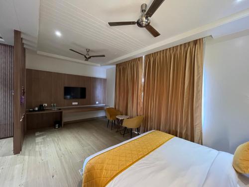 a hotel room with a bed and a desk at Hotel Three Seasons in Vrindāvan