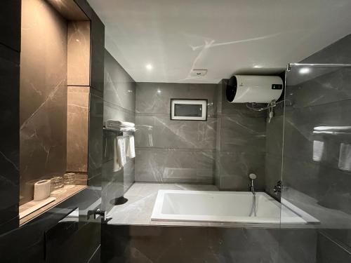 a bathroom with a bath tub and a shower at Hotel Three Seasons in Vrindāvan