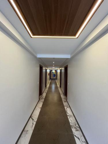 a corridor in a building with white walls and a ceiling at Hotel Three Seasons in Vrindāvan