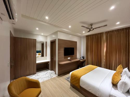 a hotel room with a bed and a television at Hotel Three Seasons in Vrindāvan