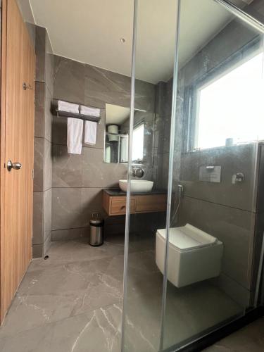 a bathroom with a shower and a toilet and a sink at Hotel Three Seasons in Vrindāvan