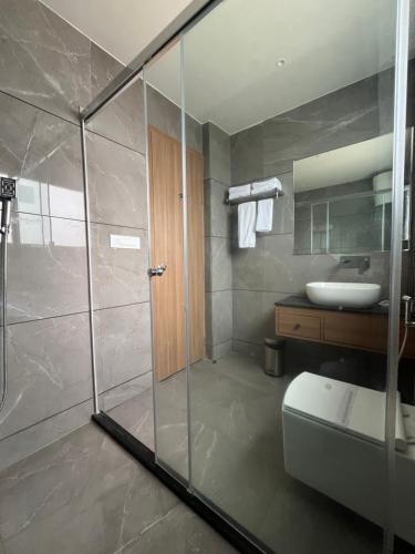 uma casa de banho com um chuveiro, um WC e um lavatório. em Hotel Three Seasons em Vrindāvan