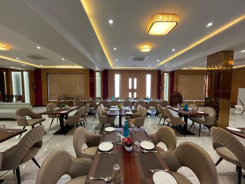 Hotel Three Seasons في فريندافان: مطعم فيه طاولات وكراسي في الغرفة