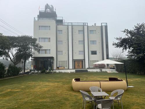 a building with a table and chairs in front of it at Hotel Three Seasons in Vrindāvan