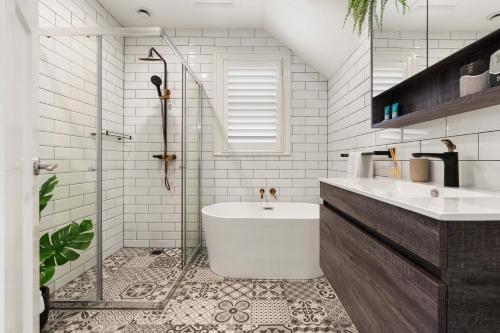 a bathroom with a tub and a sink and a shower at Boutique Apartment With Private Roof Terrace in Sydney