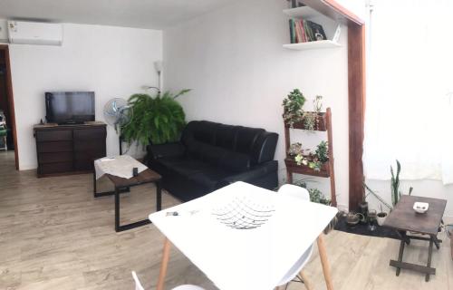 een woonkamer met een zwarte bank en een tafel bij ALCA Apartamento exclusivo a 80 mts de Playa Pocitos in Montevideo