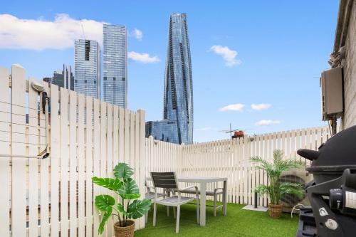 a patio with a fence and a table and chairs at Boutique Apartment With Private Roof Terrace in Sydney