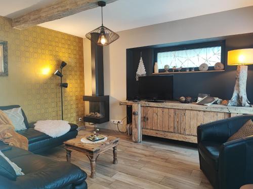 uma sala de estar com um sofá e uma televisão de ecrã plano em G'Ardenne Blue em Durbuy