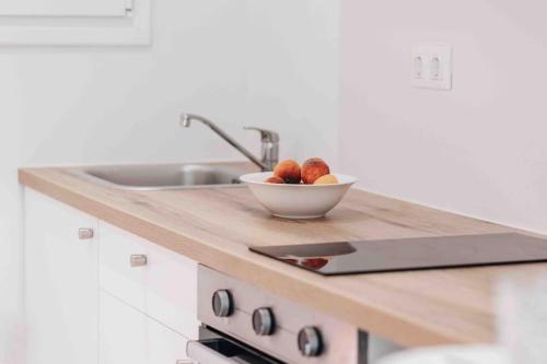 a bowl of fruit on a counter in a kitchen at E&G Figareto apartments 10 in Kanoni
