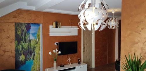 uma sala de estar com um lustre e uma televisão em Lux Apartments With Pool Dex em Zemun Polje