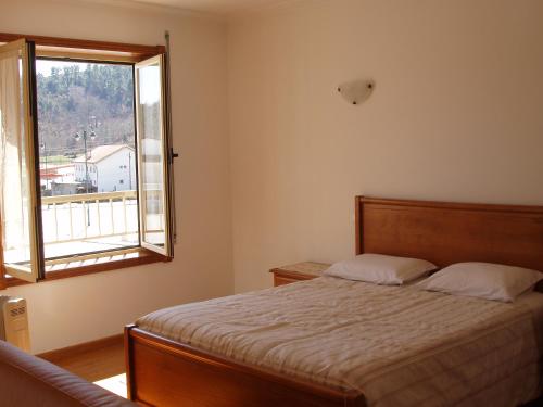 a bedroom with a bed and a window at Casa de Sao Cristovao in Boticas