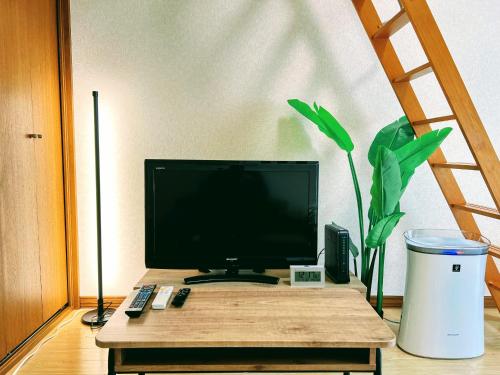 東京的住宿－メゾンクレスタ，桌子上带有盆栽的电脑显示器