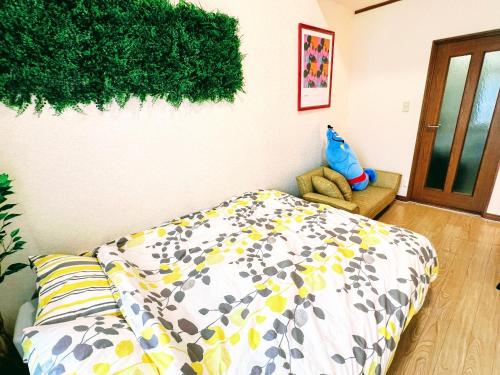 東京的住宿－メゾンクレスタ，卧室配有一张床,墙上挂着植物