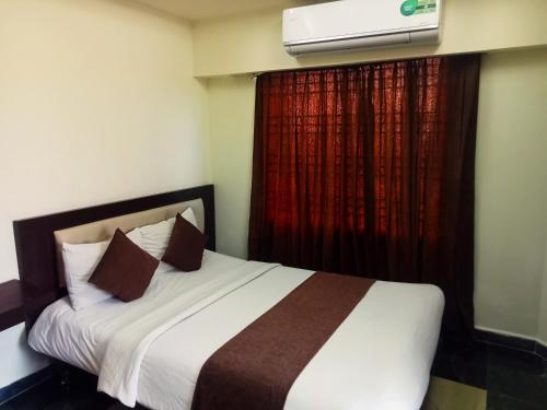 a bedroom with a bed and a window with a heater at Hotel Suite Sadaf in Kelātali