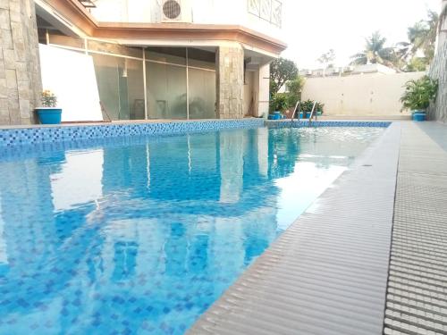 a swimming pool in front of a building at Hotel Suite Sadaf in Kelātali