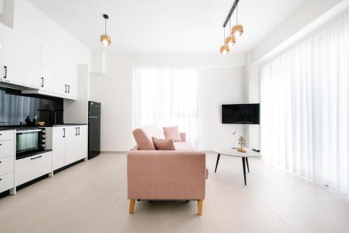 a white living room with a chair and a table at Ennea Suites-Luna suite in Flámbouras