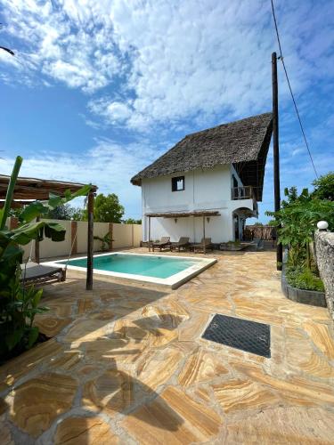 a villa with a swimming pool and a house at Chunga Changa in Matemwe