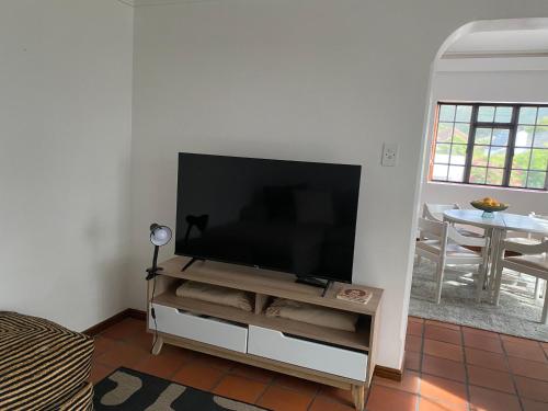 a flat screen tv sitting on a stand in a living room at Barford Haven in Hermanus