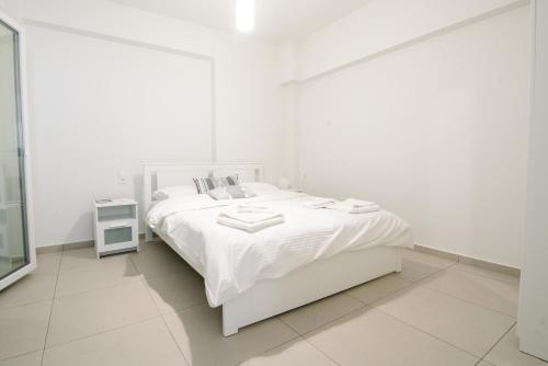 a white bedroom with a white bed and a window at Ennea Suites-Luna suite in Flámbouras