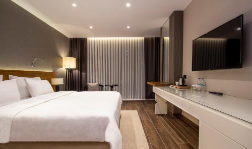 a hotel room with a white bed and a desk at Elite World Comfy Samsun Atakum in Atakum