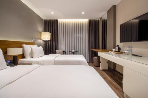 a hotel room with two beds and a desk at Elite World Comfy Samsun Atakum in Atakum