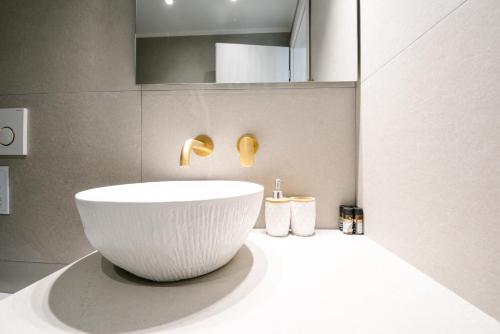a bathroom with a white bowl sink on a counter at Ennea Suites-Luna suite in Flámbouras
