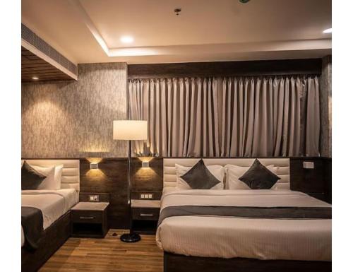 a hotel room with two beds and a lamp at Hotel Silk Inn, Gosaba, West Bengal in Ingrāj Bāzār