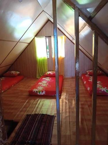 a room with two beds in a tent at Maupiti Authentique in Te-Fare-Arii