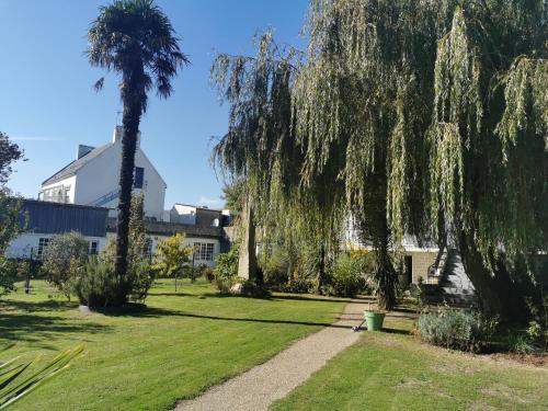 a garden with a palm tree and a building at ARVEIL in Plomeur