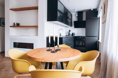 een eetkamer met een houten tafel en gele stoelen bij Seaside Apartment in Liepāja