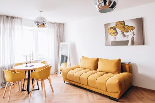 een woonkamer met een gele bank en een tafel bij Seaside Apartment in Liepāja