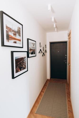 a hallway with pictures on the walls and a door at Seaside Apartment in Liepāja