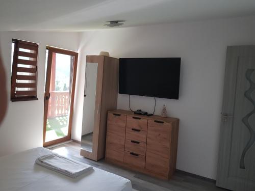 a living room with a television on a dresser at Cabana Anisoara-Rimetea in Rimetea
