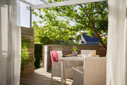 a patio with a table and chairs on a deck at Spanish Farm Boutique Hotel & Villas in Somerset West