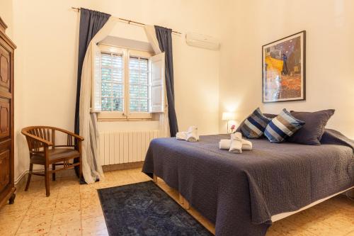 a bedroom with a bed and a chair and a window at Villa Maresme in Cabrils