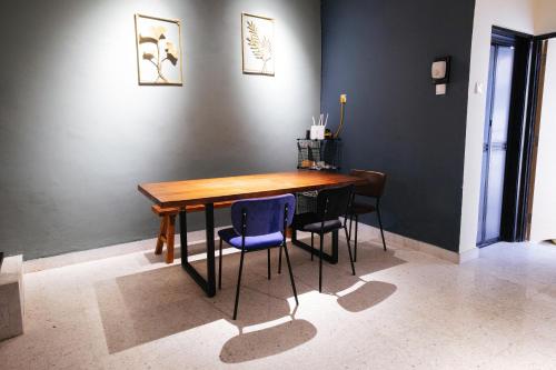 a dining room with a wooden table and chairs at monstera guesthouse @ Ipoh Garden East in Ipoh