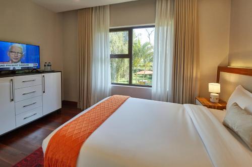 sypialnia z dużym łóżkiem i telewizorem w obiekcie Deerpark Luxury Stays w mieście Nairobi