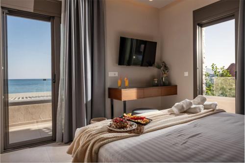 a bedroom with a bed with a view of the ocean at Horizon Beachfront Apartments in Laganas