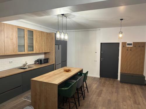 eine Küche mit einem Holztisch und grünen Stühlen in der Unterkunft Apartament lângă VIVO in Floreşti