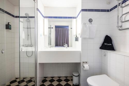 a bathroom with a sink and a toilet and a shower at Comfort Hotel Vesterbro in Copenhagen