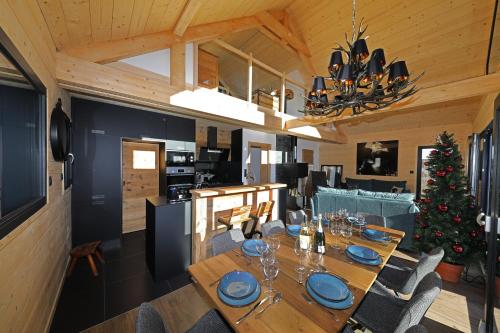 une salle à manger avec une table et un sapin de Noël dans l'établissement Chalet l'URSUS - séjour premium avec vue montagne, à Gérardmer