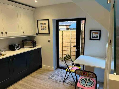uma cozinha com um balcão, uma mesa e cadeiras em Squirrels Leap - beautiful one bed apartment em Alderley Edge