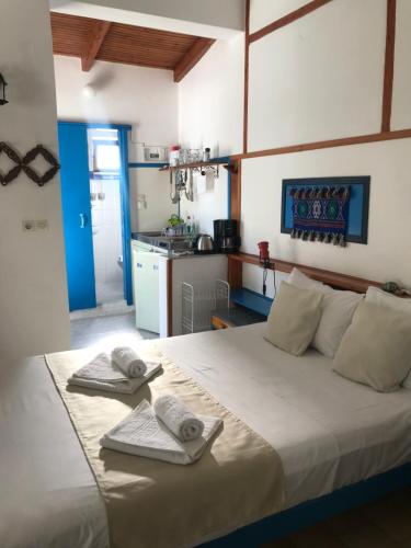 a bedroom with a large bed with towels on it at Oleander's Garden Traditional Cretan Cottage in Ferma